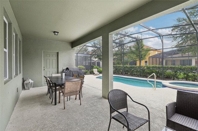 7033 Oakwood St, Davenport, FL 33837 - view of pool featuring a patio, a pool with connected hot tub, glass enclosure, outdoor dining space, and area for grilling