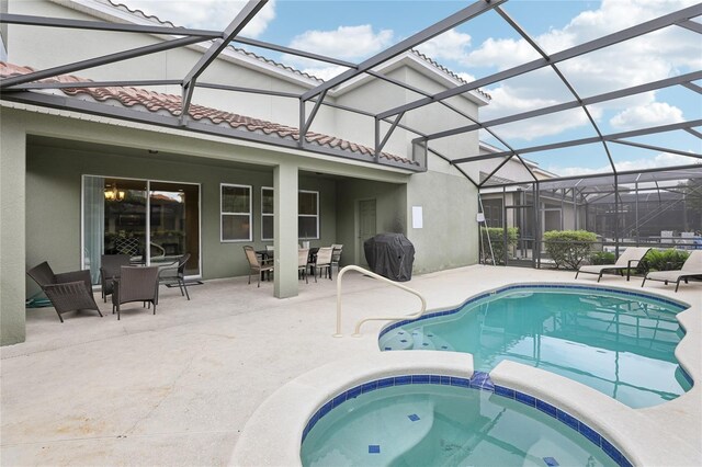 7033 Oakwood St, Davenport, FL 33837 - view of swimming pool with area for grilling, outdoor dining area, a patio area, a pool with connected hot tub, and glass enclosure