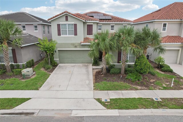 7033 Oakwood St, Davenport, FL 33837 - view of front of home featuring a garage, concrete driveway, stucco siding, a tile roof, and solar panels
