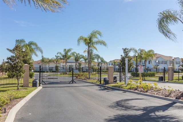 3203 Oyster Ln, Kissimmee, FL 34747 - view of asphalt street with a residential view, a gated entry, a gate, and curbs