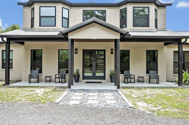 2459 Mcgregor Oaks Ln, Deland, FL 32720 - entrance to property featuring stucco siding, french doors, metal roof, and a patio area