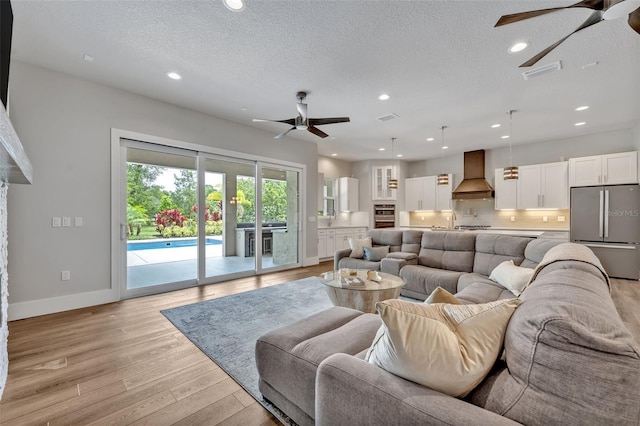 2459 Mcgregor Oaks Ln, Deland, FL 32720 - living room featuring ceiling fan, light wood finished floors, baseboards, recessed lighting, and a textured ceiling