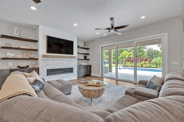 2459 Mcgregor Oaks Ln, Deland, FL 32720 - living area with a ceiling fan, wood finished floors, a textured ceiling, a fireplace, and recessed lighting