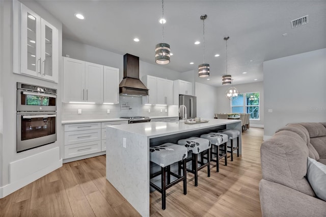 2459 Mcgregor Oaks Ln, Deland, FL 32720 - kitchen featuring custom exhaust hood, open floor plan, appliances with stainless steel finishes, light countertops, and a kitchen breakfast bar