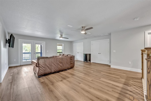 2459 Mcgregor Oaks Ln, Deland, FL 32720 - living area with a ceiling fan, light wood-style floors, french doors, baseboards, and a textured ceiling