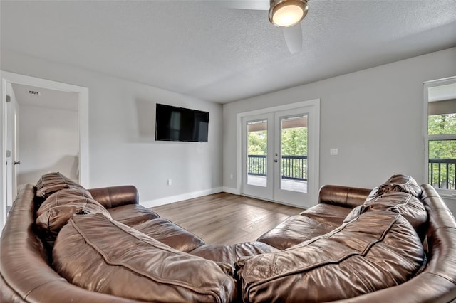 2459 Mcgregor Oaks Ln, Deland, FL 32720 - living room featuring french doors, wood finished floors, a ceiling fan, a textured ceiling, and baseboards
