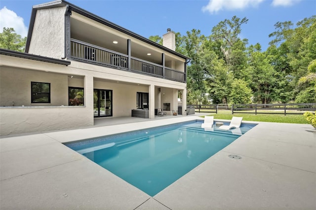 2459 Mcgregor Oaks Ln, Deland, FL 32720 - rear view of property with a balcony, a patio, a chimney, and stucco siding