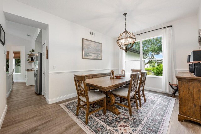 10241 Pointview Ct, Orlando, FL 32836 - dining room featuring light wood-style flooring, a chandelier, baseboards, and lofted ceiling