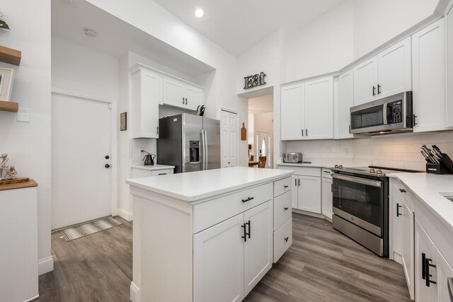 10241 Pointview Ct, Orlando, FL 32836 - kitchen with stainless steel appliances, decorative backsplash, wood finished floors, light countertops, and white cabinetry
