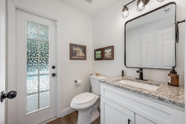 10241 Pointview Ct, Orlando, FL 32836 - half bathroom featuring vanity, toilet, wood finished floors, and baseboards