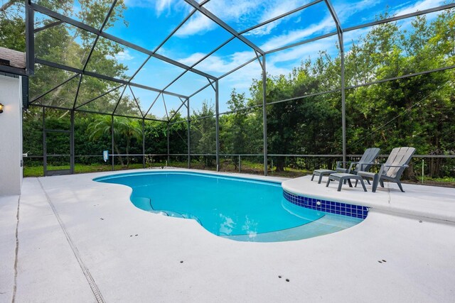 10241 Pointview Ct, Orlando, FL 32836 - swimming pool featuring a patio, a lanai, and view of scattered trees