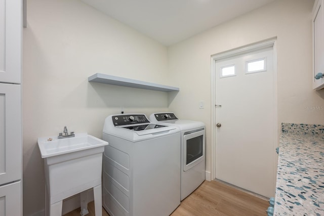 5108 Saint Albans Ave, Siesta Key, FL 34242 - washroom featuring independent washer and dryer, cabinet space, and light wood-style floors