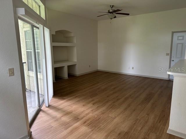 7350 Westpointe Blvd Unit 234, Orlando, FL 32835 - spare room featuring ceiling fan, light wood-type flooring, built in features, and baseboards