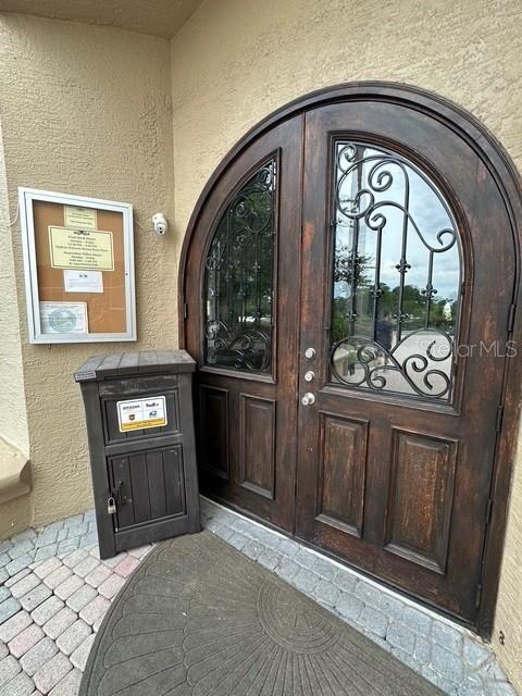 7350 Westpointe Blvd Unit 234, Orlando, FL 32835 - doorway to property with stucco siding and a security system