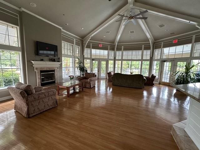 7350 Westpointe Blvd Unit 234, Orlando, FL 32835 - living area featuring a high ceiling, a glass covered fireplace, ceiling fan, wood finished floors, and french doors