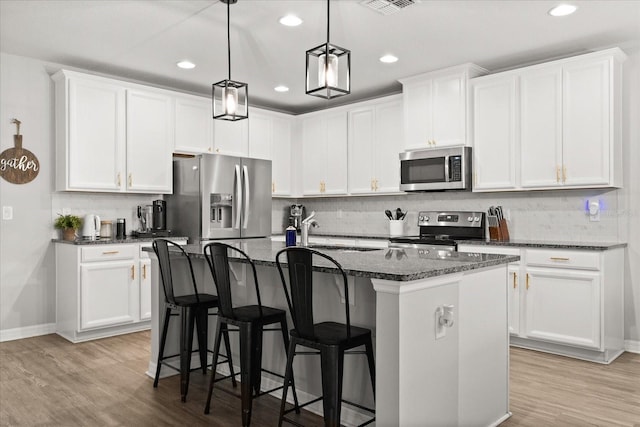 17416 Painted Leaf Way, Clermont, FL 34714 - kitchen with stainless steel appliances, decorative backsplash, a breakfast bar, an island with sink, and a sink