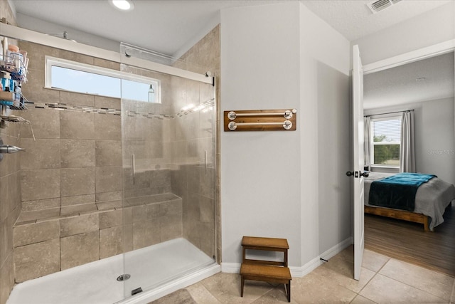 17416 Painted Leaf Way, Clermont, FL 34714 - ensuite bathroom featuring a stall shower, plenty of natural light, tile patterned floors, and baseboards