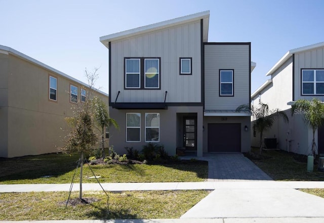 8986 Cabot Cliffs Dr, Davenport, FL 33896 - modern home with board and batten siding, central air condition unit, driveway, a garage, and a front lawn