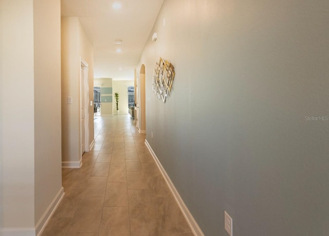 8986 Cabot Cliffs Dr, Davenport, FL 33896 - hall featuring arched walkways, light tile patterned floors, and baseboards