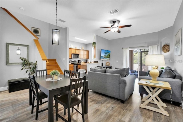 3214 Calabria Ave, Davenport, FL 33897 - dining area featuring light wood finished floors, stairs, a ceiling fan, and baseboards