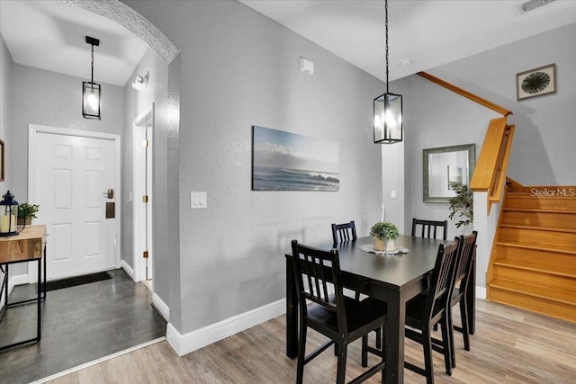3214 Calabria Ave, Davenport, FL 33897 - dining area with wood finished floors, arched walkways, baseboards, stairs, and a textured wall