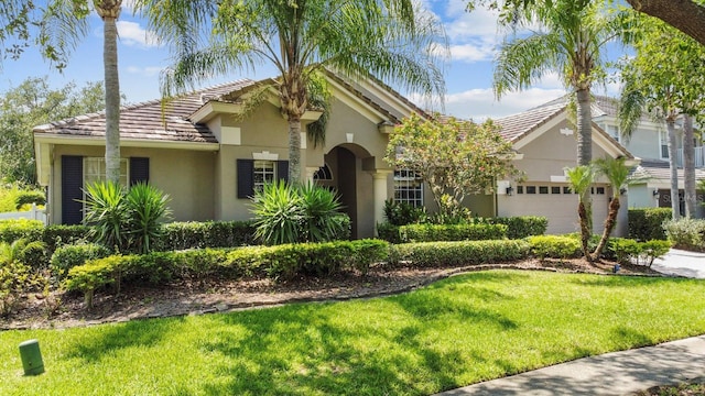 3307 Kentshire Blvd, Ocoee, FL 34761 - view of front of home featuring stucco siding, a tiled roof, a front yard, and a garage