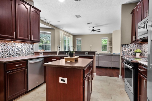 3307 Kentshire Blvd, Ocoee, FL 34761 - kitchen with appliances with stainless steel finishes, a sink, dark countertops, open floor plan, and a textured ceiling