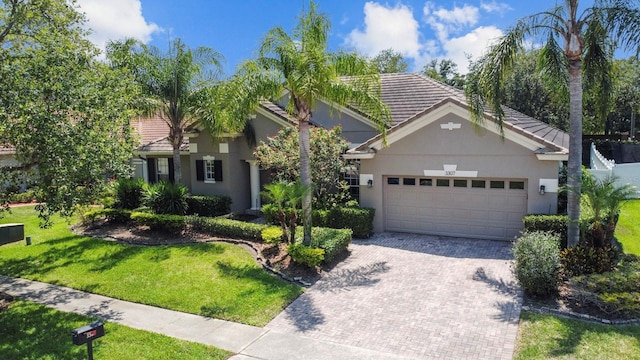 3307 Kentshire Blvd, Ocoee, FL 34761 - view of front facade with an attached garage, decorative driveway, stucco siding, a front yard, and a tile roof