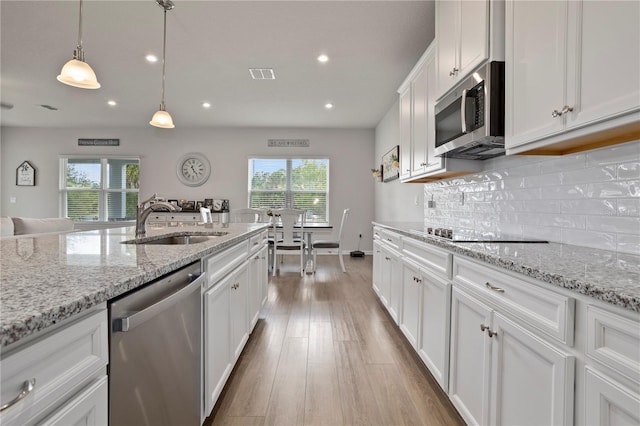 2168 Aibonito Cir, Clermont, FL 34711 - kitchen with appliances with stainless steel finishes, recessed lighting, white cabinets, wood finished floors, and decorative backsplash