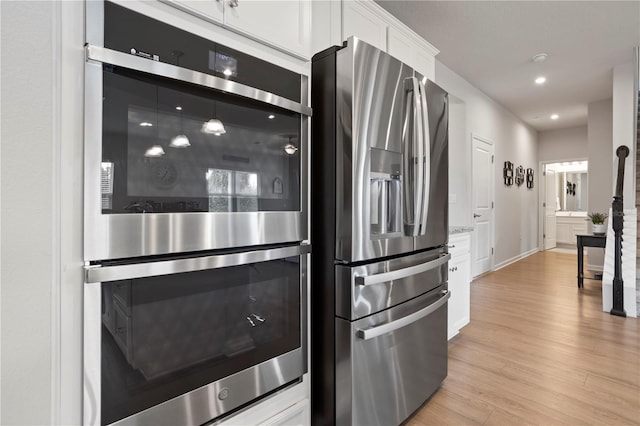 2168 Aibonito Cir, Clermont, FL 34711 - kitchen with stainless steel appliances, white cabinets, light wood finished floors, and recessed lighting