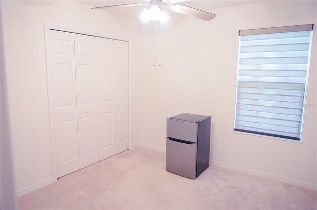 130 Claire Ln, Davenport, FL 33837 - unfurnished bedroom with refrigerator, light carpet, a closet, and a ceiling fan