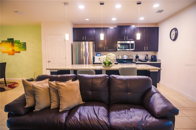 130 Claire Ln, Davenport, FL 33837 - kitchen featuring stainless steel appliances, open floor plan, an island with sink, light stone counters, and hanging light fixtures