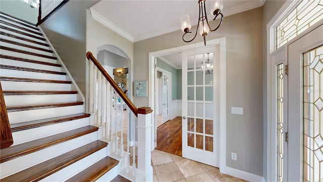 10809 Arrowtree Blvd, Clermont, FL 34715 - foyer entrance with a chandelier, crown molding, french doors, stairway, and light tile patterned floors