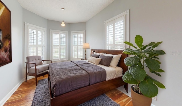 10809 Arrowtree Blvd, Clermont, FL 34715 - bedroom with multiple windows, light wood finished floors, and baseboards