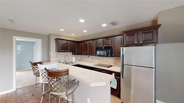 10809 Arrowtree Blvd, Clermont, FL 34715 - kitchen featuring black appliances, dark brown cabinetry, tasteful backsplash, light tile patterned floors, and a kitchen island
