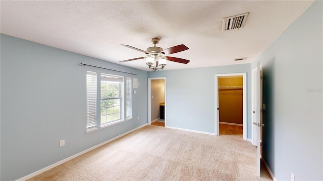 10809 Arrowtree Blvd, Clermont, FL 34715 - unfurnished bedroom featuring a walk in closet, baseboards, carpet floors, a closet, and a ceiling fan