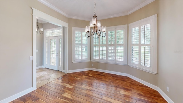 10809 Arrowtree Blvd, Clermont, FL 34715 - unfurnished dining area with a chandelier, wood-type flooring, healthy amount of natural light, crown molding, and baseboards