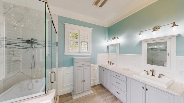 10809 Arrowtree Blvd, Clermont, FL 34715 - bathroom with crown molding, a wainscoted wall, a marble finish shower, wood finished floors, and double vanity