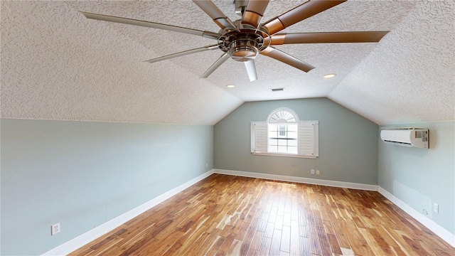 10809 Arrowtree Blvd, Clermont, FL 34715 - bonus room with a textured ceiling, wood finished floors, baseboards, a wall unit AC, and vaulted ceiling