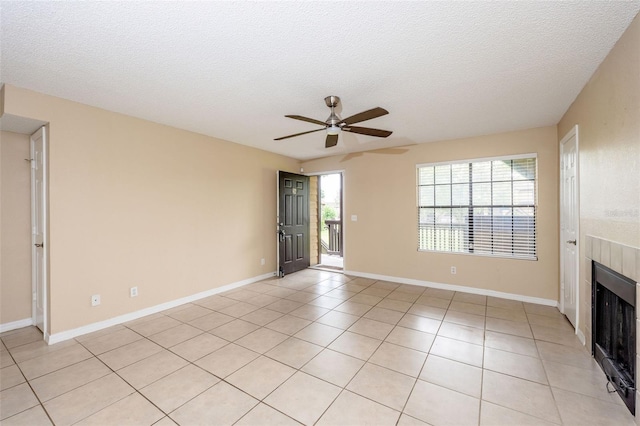 420 Forestway Cir Unit 206, Altamonte Springs, FL 32701 - unfurnished living room featuring a ceiling fan, a fireplace, a textured ceiling, and light tile patterned floors