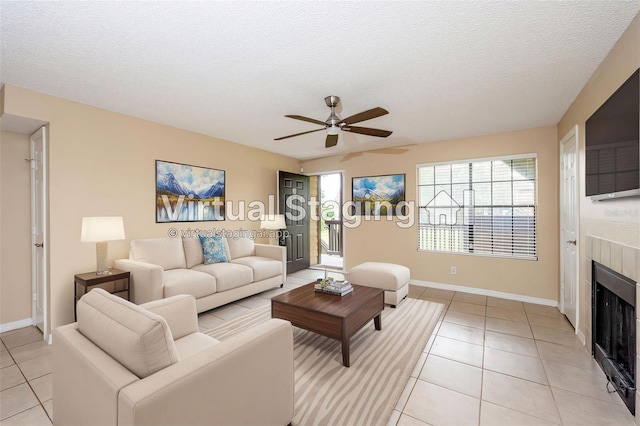 420 Forestway Cir Unit 206, Altamonte Springs, FL 32701 - living room featuring ceiling fan, light tile patterned floors, a fireplace, a textured ceiling, and baseboards