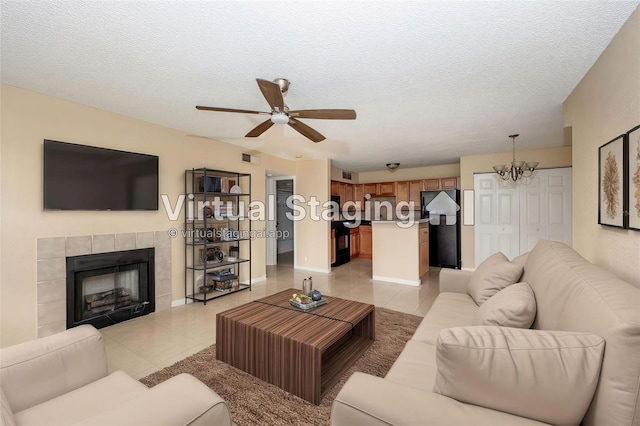 420 Forestway Cir Unit 206, Altamonte Springs, FL 32701 - living area featuring light tile patterned floors, a chandelier, a ceiling fan, a textured ceiling, and a tile fireplace