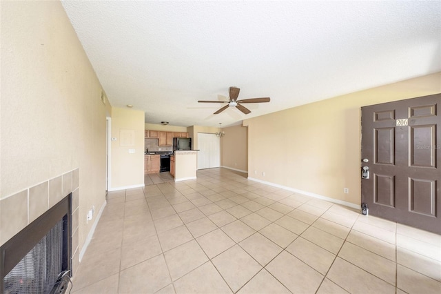 420 Forestway Cir Unit 206, Altamonte Springs, FL 32701 - unfurnished living room with ceiling fan, light tile patterned flooring, a tiled fireplace, and baseboards