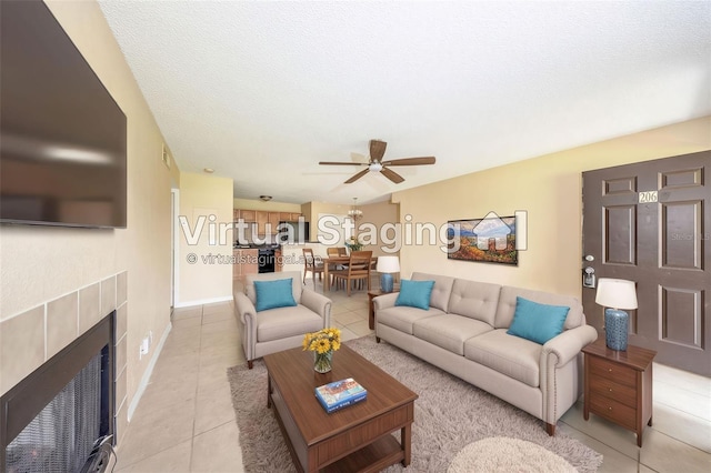 420 Forestway Cir Unit 206, Altamonte Springs, FL 32701 - living area with light tile patterned floors, ceiling fan, a fireplace, baseboards, and a textured ceiling