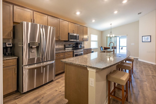 5416 Tessin Trl, Saint Cloud, FL 34771 - kitchen featuring stainless steel appliances, a sink, vaulted ceiling, a breakfast bar area, and recessed lighting