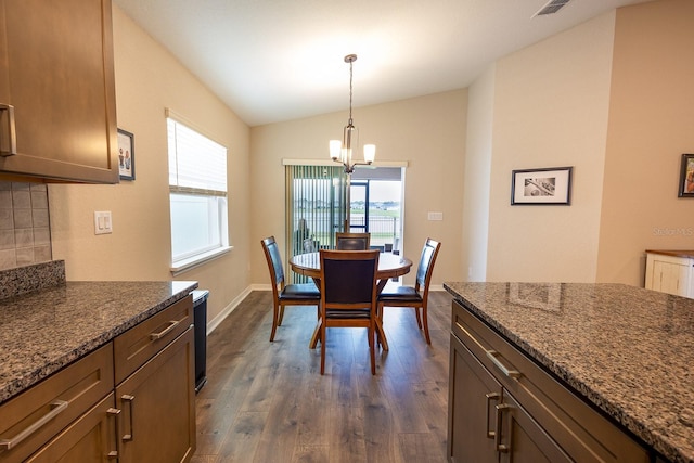 5416 Tessin Trl, Saint Cloud, FL 34771 - dining space with a chandelier, dark wood-style flooring, lofted ceiling, and baseboards