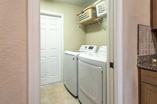 5416 Tessin Trl, Saint Cloud, FL 34771 - laundry area with a textured wall, washer and dryer, and light tile patterned floors