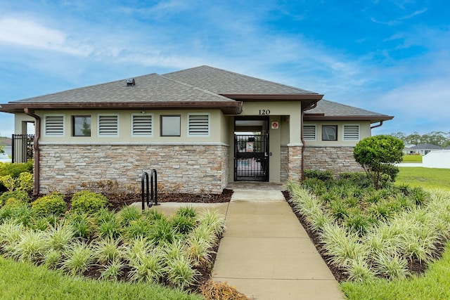 5416 Tessin Trl, Saint Cloud, FL 34771 - view of front of house featuring stone siding, stucco siding, roof with shingles, and a gate