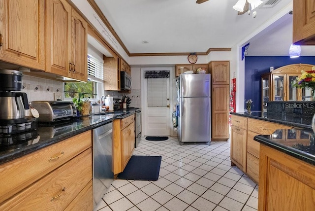 3405 Werber St, Orlando, FL 32806 - kitchen featuring stainless steel appliances, a sink, backsplash, light tile patterned floors, and crown molding