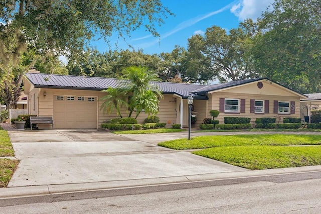3405 Werber St, Orlando, FL 32806 - ranch-style home with driveway, an attached garage, a standing seam roof, and metal roof
